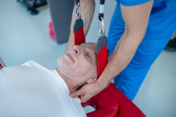 Спокійний літній чоловік і лікар дає масаж шиї — стокове фото