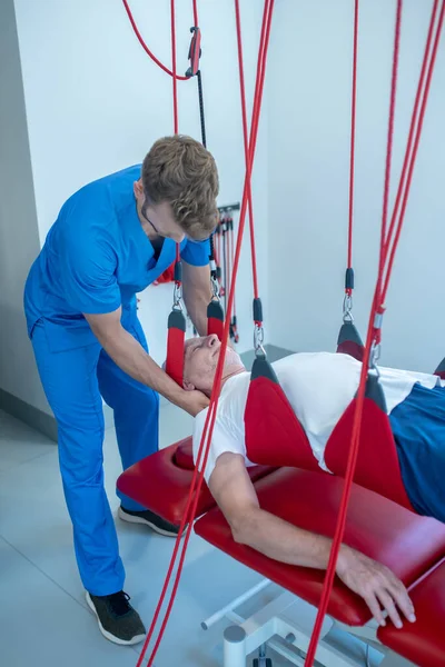 Ameliyat sırasında genç erkek rehabilitasyon uzmanı ve hasta.