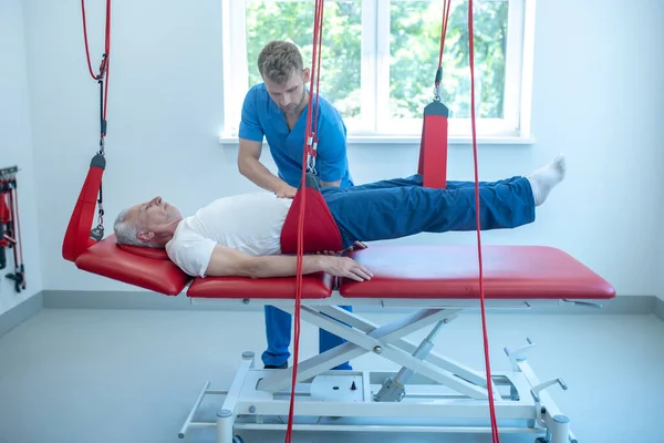 Hastanın yanındaki kanepede genç bir doktor var.