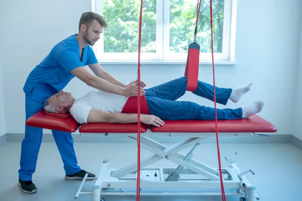 Özenli profesyonel doktor, rehabilitasyon uzmanı ve hasta.