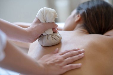 Koyu renk saçlı genç bir kadın çantalara masaj yaptırıyor.