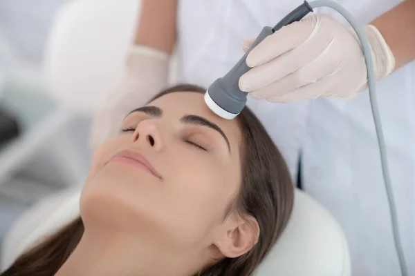 Cosmetoloog maakt lasergezicht gladstrijken aan de klant — Stockfoto