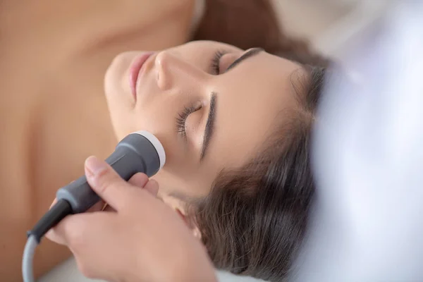 Young woman lying down while beauty procedures — Stock Photo, Image