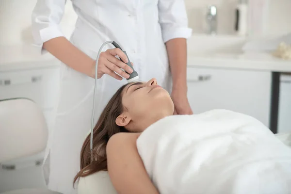 Cosmetoloog werkt met een vrouwelijke klant in een schoonheidssalon — Stockfoto