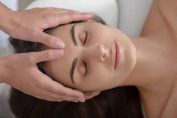 Professionelle Massagetherapeutin massiert Stirn einer Frau — Stockfoto