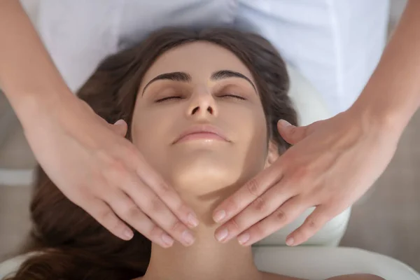 Professional massage therapist putting hands on customers neck — Stock Photo, Image