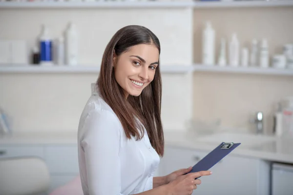 Bastante joven profesional de pie en la habitación y buscando alegre — Foto de Stock