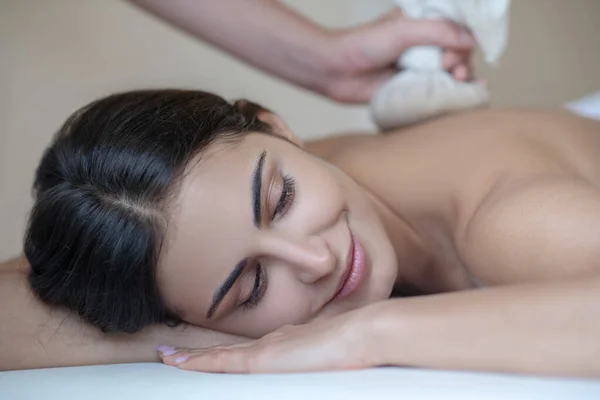 Ung kvinna som har ayurvedisk massage och känner sig avslappnad — Stockfoto