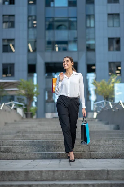 Schöne dunkelhaarige stilvolle Frau, die sich nach dem Einkaufen gut fühlt — Stockfoto