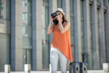 Şapkalı hoş bir genç kadın fotoğraf çekiyor.