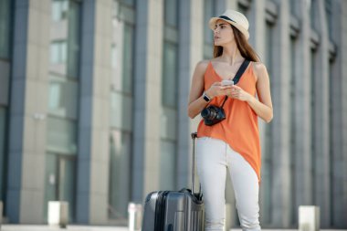 Siyah saçlı, şapkalı genç bir kadın endişeli görünüyor.