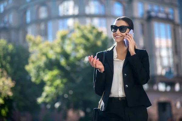 Elegante mujer morena hablando emocionalmente por teléfono — Foto de Stock