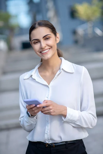 Mujer elegante en una camisa blanca sintiéndose satisfecha — Foto de Stock