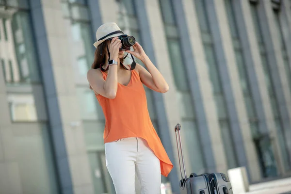 Mujer joven de cabello oscuro en un sombrero haciendo fotos — Foto de Stock