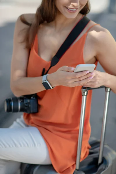 Närbild på en kvinna som sitter med resväskan — Stockfoto