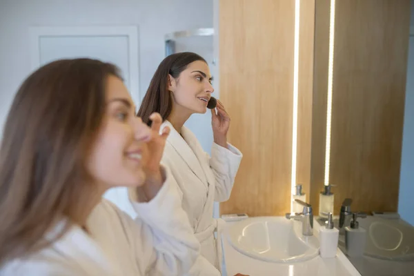 Dos chicas guapas haciendo maquillaje cerca del espejo — Foto de Stock