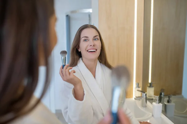 Zwei hübsche Mädchen machen Make-up in der Nähe des Spiegels und genießen — Stockfoto