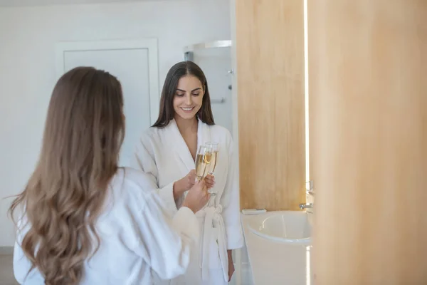 Zwei hübsche Mädchen verbringen Zeit miteinander und trinken Champagner — Stockfoto