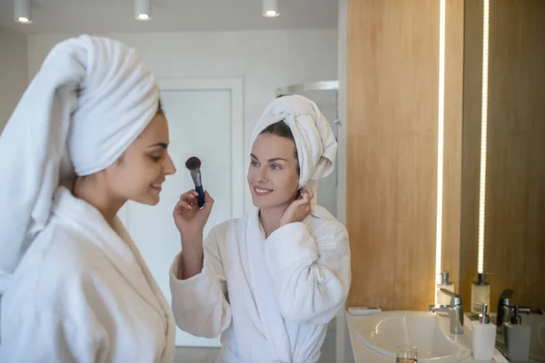 Two pretty girls having fun and doing make up — Stock Photo, Image