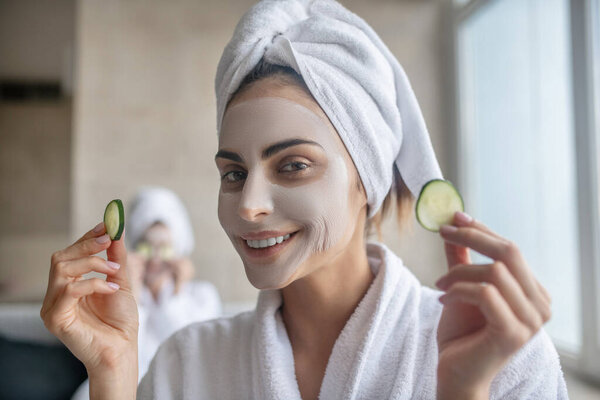 Young woman with towel on her head having face beauty treatment