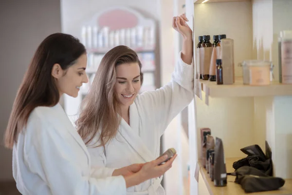 Twee mooie vrouwen kiezen schoonheid producten in salon — Stockfoto