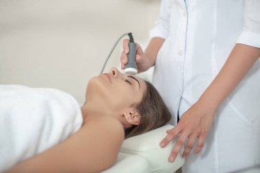 Klinikte lazer yüz tedavisi gören kadın hasta.