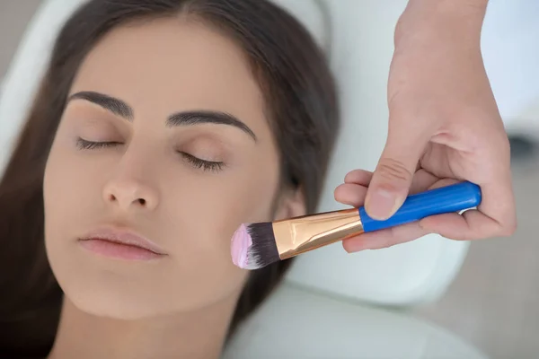 Cosmetoloog aanbrengen van gezichtsmasker op haar klanten gezicht — Stockfoto