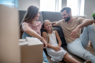 Aile koltukta dinleniyor ve gülümsüyor.