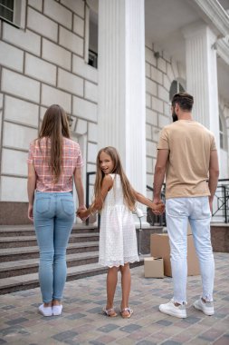 Yeni evlerinin yanında duran genç bir aile.