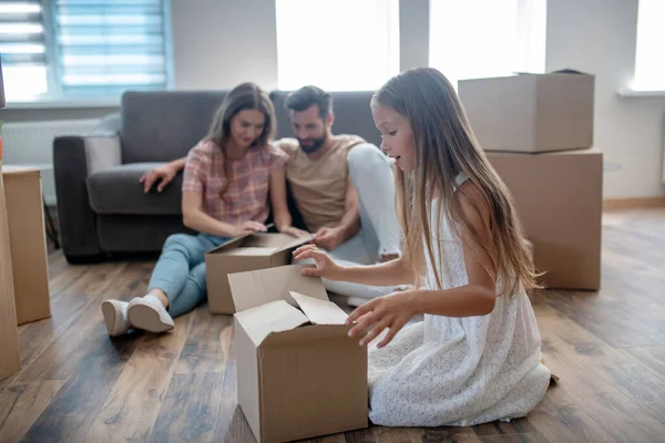 Family unpacking cardboards in a new house — Stock Photo, Image