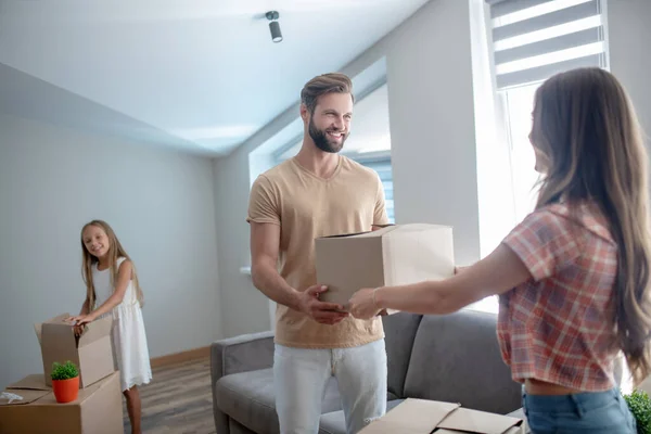 Familia desempacando sus cosas en una nueva casa y sintiéndose emocionados — Foto de Stock