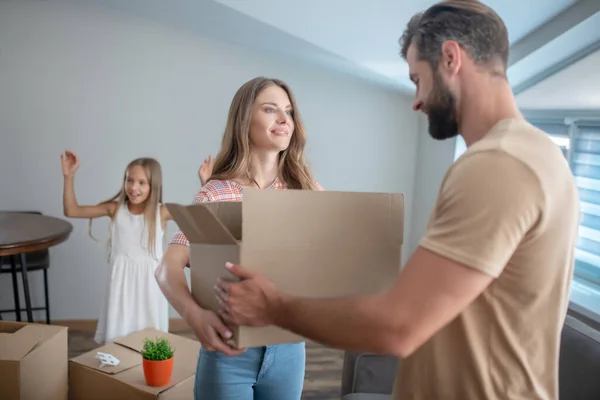 Young man passing the cardboard to his wife — Stock Photo, Image