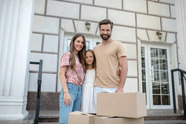 Young family standing near boxes and smiling