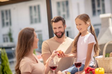 Sevimli kız annesine şeftali veriyor.