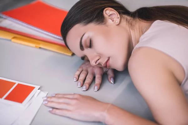 Dormindo feminino de cabelos castanhos, descansando a cabeça na mesa — Fotografia de Stock