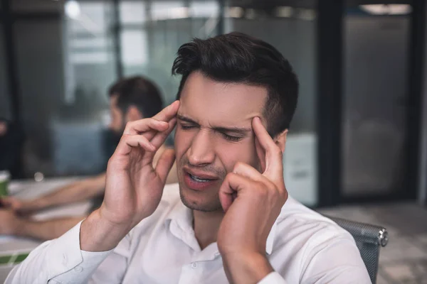 Homme brun fatigué ayant mal à la tête, touchant ses tempes — Photo