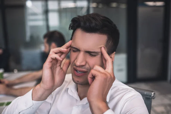 Cansado macho moreno con dolor de cabeza, tocando sus sienes — Foto de Stock