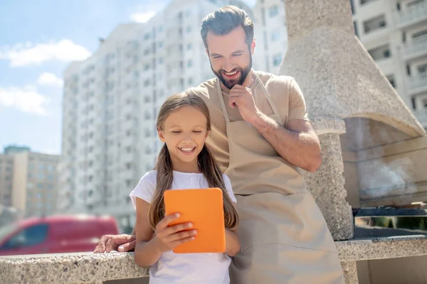 Dad and daughter watching something on a tablet — Stock Photo, Image