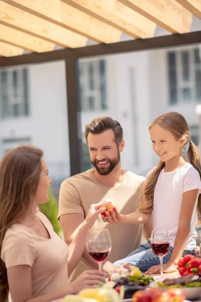 Jovem família bonito sentado na mesa de jantar — Fotografia de Stock