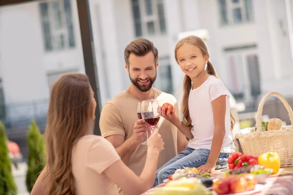 Anne ve baba, çocuklarıyla yemek yerken kadeh kaldırıyorlar. — Stok fotoğraf