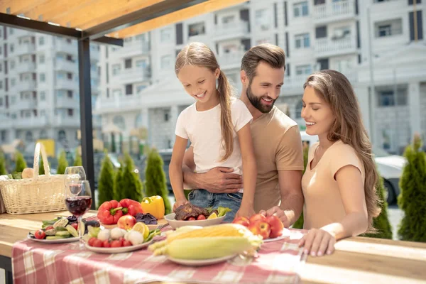 Joven linda familia cenando afuera y luciendo feliz — Foto de Stock