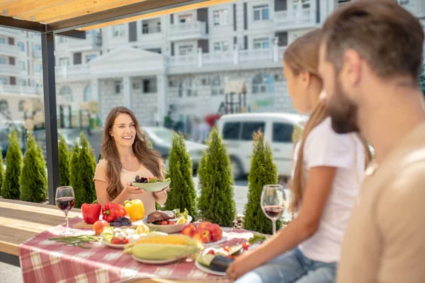 Família sentada na mesa servida e olhando satisfeito — Fotografia de Stock