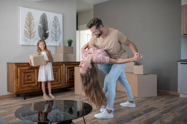 Pareja casada bailando en una casa nueva y luciendo feliz — Foto de Stock