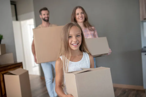 Family moving into new house and carrying cardoards — Stock Photo, Image