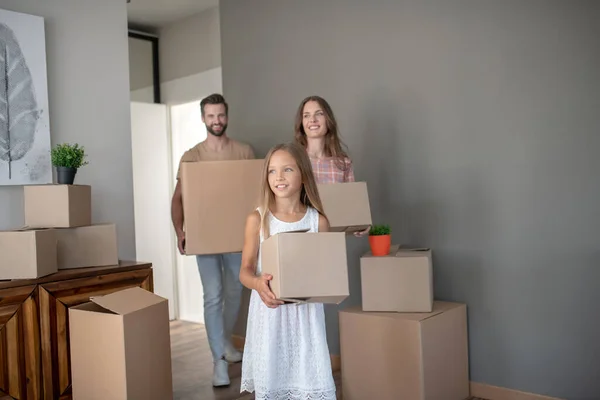 Jovem família se mudando para nova casa com papelão — Fotografia de Stock