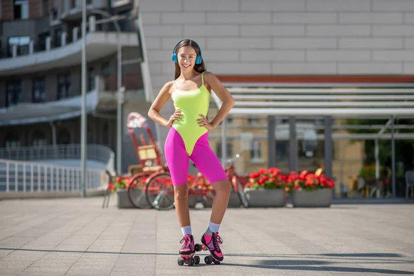 Дівчина в яскравому спортивному одязі і роликах виглядає придатною — стокове фото
