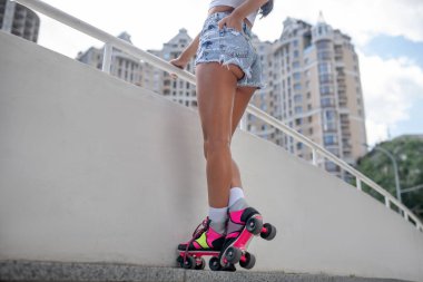 Kot şortlu, patenli güzel bir kız.