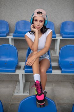 Koyu saçlı, patenli, müzik dinleyen ve rüya gören bir kız.