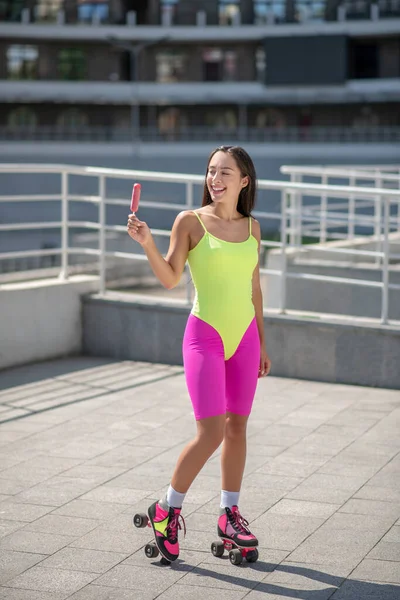 Chica en ropa deportiva brillante y patines con helado —  Fotos de Stock