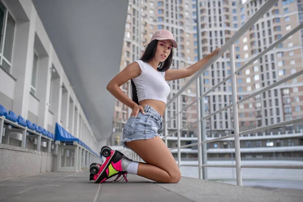 Fit meisje in rolschaatsen staan op haar knieën — Stockfoto